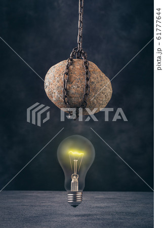 Stone hanging above light bulb 61777644