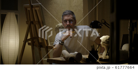 Artist sits down to his desk Artist sits down to his desk 61777664
