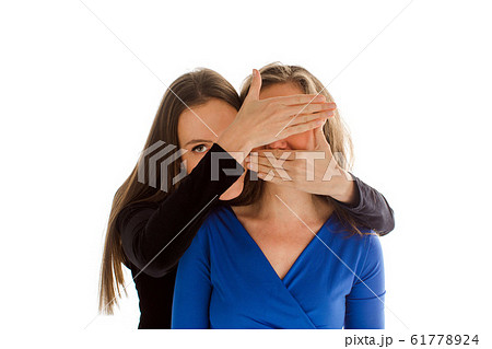Lady hiding face of anonymous woman with hands 61778924