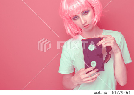 Young girl 90s and VHS cassette on pink 61779261