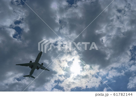 雲の多い空を飛行する一機の旅客機 61782144