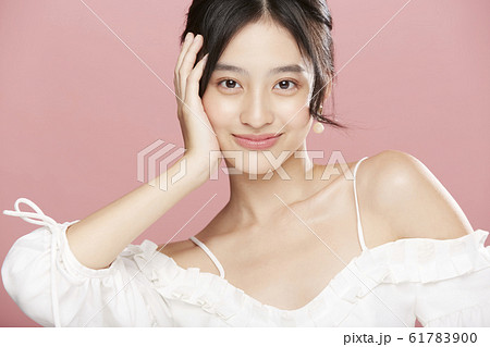 ピンク色背景の女性ビューティー写真 61783900