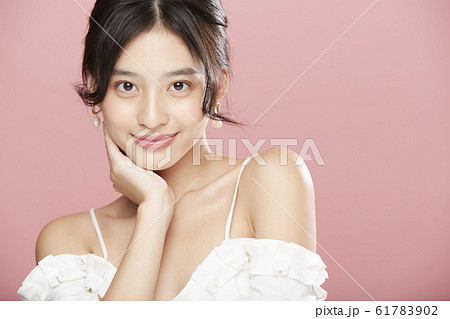 ピンク色背景の女性ビューティー写真 61783902