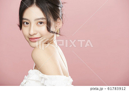 ピンク色背景の女性ビューティー写真 61783912