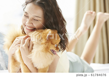 小型犬と暮らす若い女性 61784076