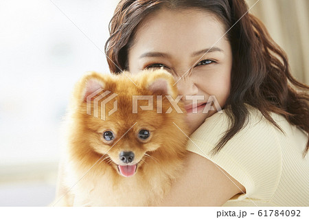 小型犬と暮らす若い女性 小型犬と暮らす若い女性 61784092