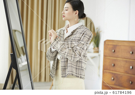 自室でドレスアップをする女性 61784196