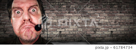 Grumpy Businessman with Frowning Face Wearing Headset 61784734