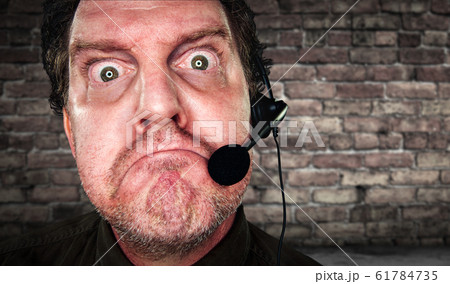 Grumpy Businessman with Frowning Face Wearing Headset 61784735