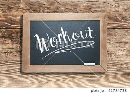 Workout Written on Slate Chalk Board Against Aged Wood 61784738