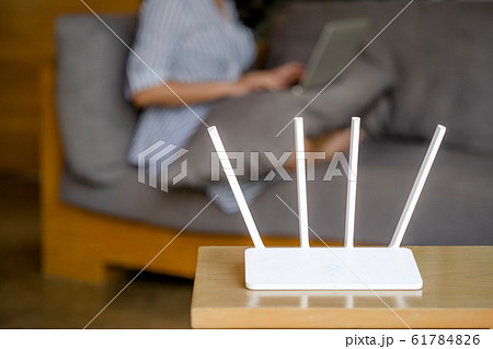 Wireless router and man using a laptop in office. 61784826
