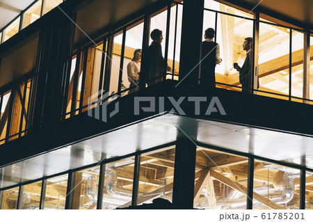 仕事の合間に話をするビジネスマンとビジネスウーマン 仕事の合間に話をするビジネスマンとビジネスウーマン 61785201