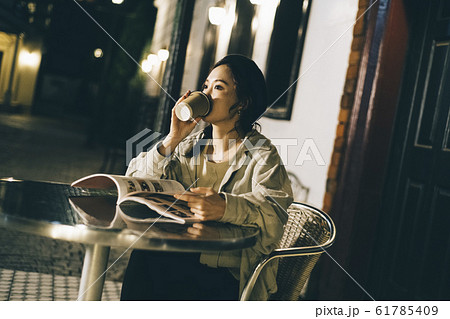 夜のカフェでくつろぐ女性 夜のカフェでくつろぐ女性 61785409