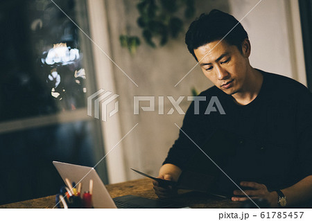 夜に部屋で仕事をする男性 61785457