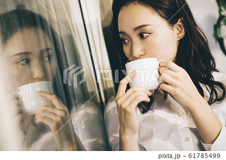 部屋でコーヒーを飲むビジネスウーマン 部屋でコーヒーを飲むビジネスウーマン 61785499