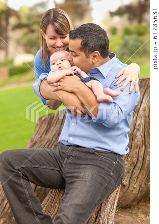Happy Mixed Race Family Posing for A Portrait Outdoors 61785631