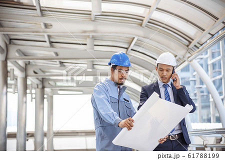 Construction engineer in Safety Suit Trust Team Holding White Yellow Safety hard hat Security  61788199