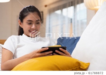 Young happy asian woman watching movie on 61788872