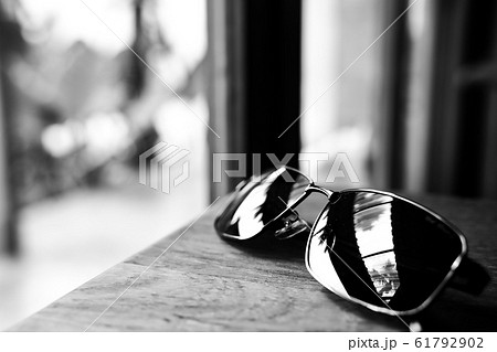 Single simple sun glasses on the wooden table with 61792902