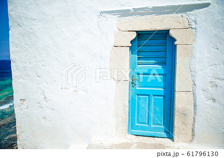 Traditional houses withe blue doors in the narrow streets of Mykonos, Greece. 61796130
