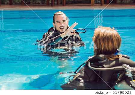 Diving instructor and students. Instructor teaches students to dive 61799022