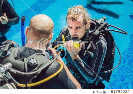 Diving instructor and students. Instructor teaches students to dive 61799024