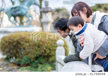 神社で遊ぶ幼児と母親 61799048