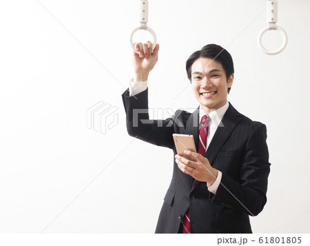 つり革につかまって微笑むビジネスマン 61801805