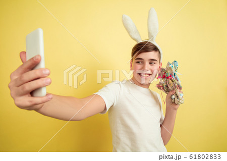 Easter bunny boy with bright emotions on yellow studio background Easter bunny boy with bright emotions on yellow studio background 61802833