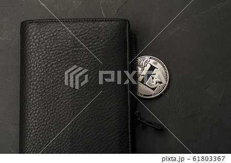 Close-up of a bitcoin coin lies on a black wallet 61803367