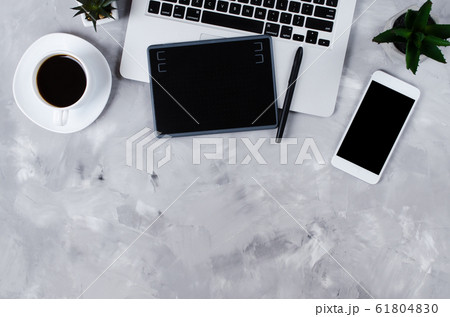 Flat lay photography of creative desk. Overhead view of graphic tablet, graphic pen, smartphone, laptop and a cup of black coffee.  61804830