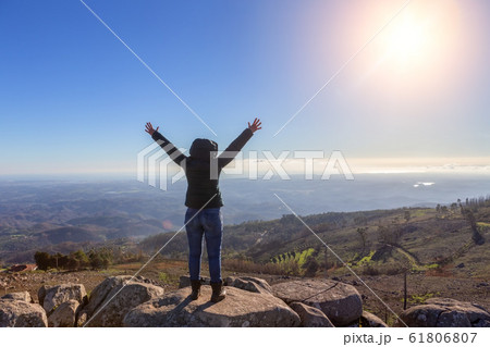 Girl woman reached the peak of the peak, admires the success, and the sun. Monchique, Foia, Portugal. 61806807