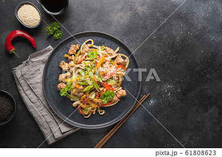 Udon with pork and vegetables on black background. 61808623