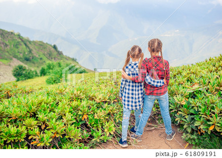 Beautiful happy little girls in mountains in the background of fog 61809191