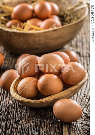 Fresh raw eggs in wooden bowl on rustic wooden Fresh raw eggs in wooden bowl on rustic wooden 61809479