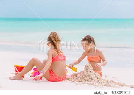Kids playing with beach toys on the white beach Kids playing with beach toys on the white beach 61809919