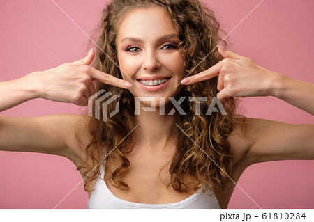 Attractive girl with curly hair isolated on pink 61810284
