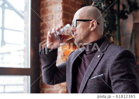 Bald man tasting whisky Bald man tasting whisky 61812365