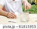 woman dropping effervescent tablet in glass of water 61815953