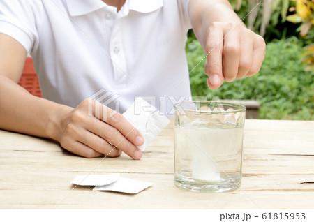 woman dropping effervescent tablet in glass of water woman dropping effervescent tablet in glass of water 61815953
