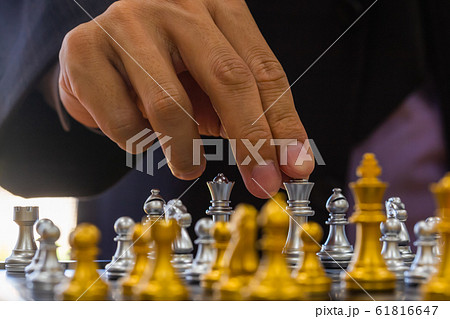 Chess game on chess board behind business man 61816647