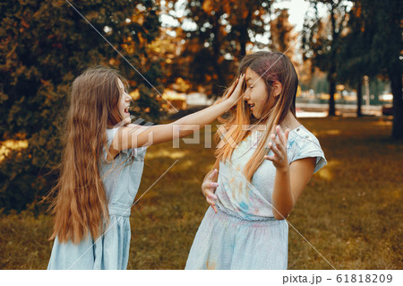 Two cute girls have fun in a summer park Two cute girls have fun in a summer park 61818209
