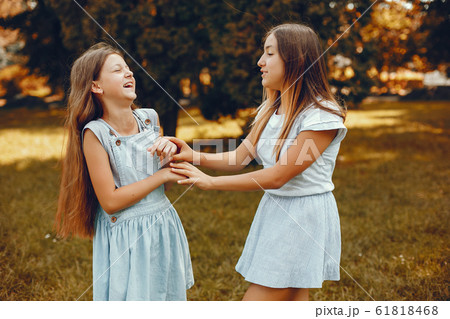 Two cute girls have fun in a summer park Two cute girls have fun in a summer park 61818468