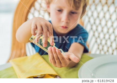 Boy using wash hand sanitizer gel in the cafe 61819428