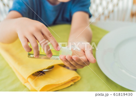 Boy using wash hand sanitizer gel in the cafe 61819430