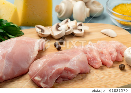 Slicing chicken breast fillet for cooking with champignons and cheese 61821570