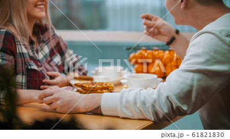 A couple in cafe having a lunch and talking to each other and holding hands A couple in cafe having a lunch and talking to each other and holding hands 61821830