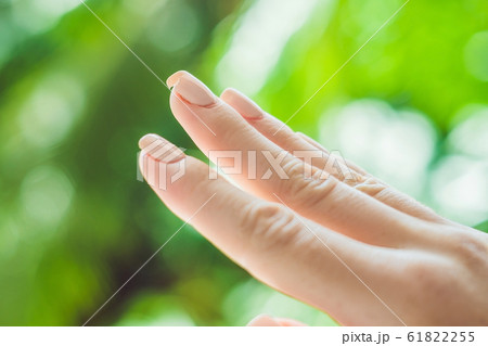 Broken nail on a woman's hand with a manicure on a green background 61822255