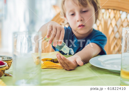 Boy using wash hand sanitizer gel in the cafe Boy using wash hand sanitizer gel in the cafe 61822410