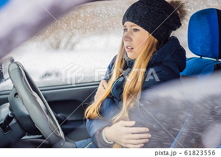 Woman in a car during a snowfall, problems on the road 61823556